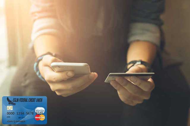person holding credit card and smartphone