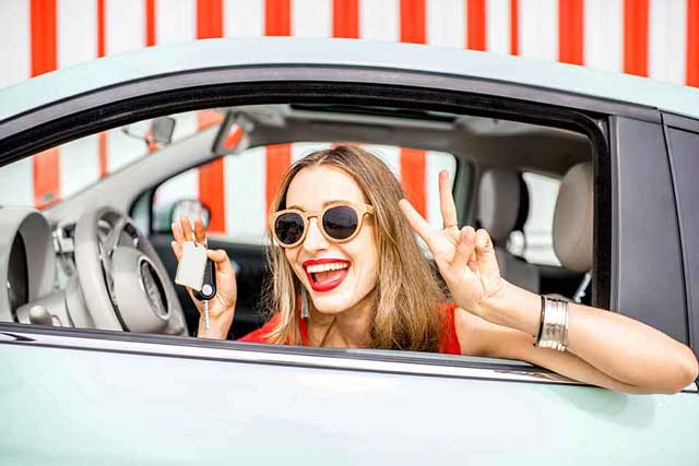 girl smiling out the window of her car